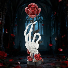 Main de squelette blanche en plastique abs tenant une rose halloween rouge en briques avec pétales thème floral