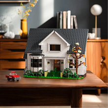 Maison blanche avec grenier à construire en plastique abs montrée avec base verte et arbre détaillé en briques lego