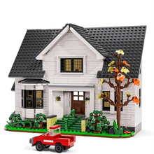 Maison blanche avec grenier à construire en plastique abs représentant une maison lego avec arbre et camion rouge devant