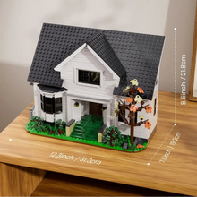 Maison blanche en plastique abs avec grenier à construire modèle lego noir et blanc sur base verte avec arbre et escaliers