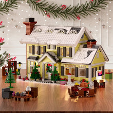 Maison de vacances de noël lumineuse en lego jaune avec toit enneigé, volets noirs et décorations festives idéale pour magasins de jouets