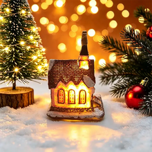 Maisonnette lumineuse de noël miniature à piles avec toit brun, fenêtres lumineuses jaunes et détails enneigés