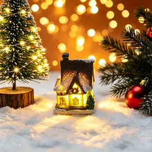 Maisonnette lumineuse de noël miniature à piles avec toit en brique et fenêtres enneigées éclairée chaleureusement