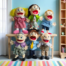 Six marionnettes à main famille en peluche colorées aux personnages expressifs posées sur une table en bois