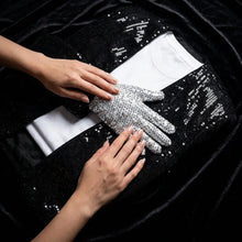 Gants en sequins argentés reposant sur une veste noire en sequins dans le déguisement michael jackson billie jean