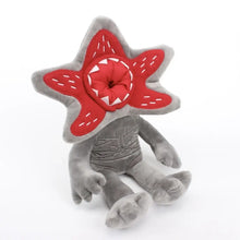 Peluche monstre fleur halloween grise avec tête rouge étoilée, couture blanche et dents acérées en tissu pelucheux