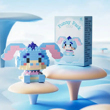Une figurine personnages disney nanoblock en bleu et rose en briques plastiques à côté de son emballage funny park