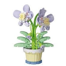 Nanoblock mini fleur en briques plastiques lavande et jaune avec tiges vertes en pot crème et base bleue, disponible en magasins de jouets
