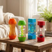 Pack 4 fidgets sensoriels anti-stress pour enfants avec liquides colorés transparents et bases vibrantes sur table en bois