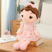 Peluche douce fille japonaise avec cheveux châtain attachés en chignon et robe rose à motifs géométriques noirs délicats