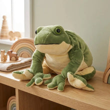 Peluche géante grenouille verte avec ventre crème et yeux noirs assise sur une surface en bois