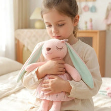 Peluche lapin longues oreilles rose doux avec oreilles vert menthe et robe rose à motifs feuilles noirs