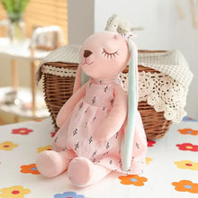 Peluche lapin longues oreilles rose en tissu doux portant une robe délicate à motifs feuille noirs et longues oreilles bleu clair
