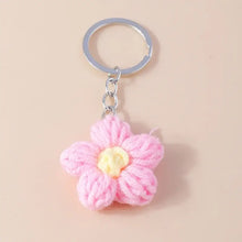 Porte-clés fleur tricotée rose avec centre jaune et anneau métallique argenté en porte-clés fleur