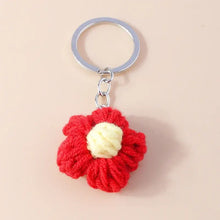 Porte-clés fleur tricotée rouge avec centre crème et anneau métallique argenté en porte clés fleurs tricotée