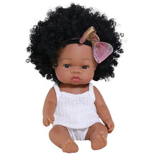 Poupon reborn à peau foncée en vinyle 35 cm avec afro noir volumineux orné dun nœud rose et or portant un haut en dentelle blanche
