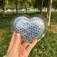 Squishy anti stress cœur gris translucide avec surface texturée de points noirs encastré dans plastique clair pour relaxation