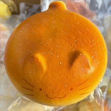 Squishy créature de la forêt orange glittery en forme de petit pain avec visage souriant et formes douces