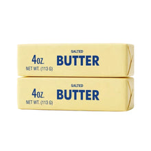 Deux bâtons de beurre salé jaune pâle emballés avec lettrage bleu indiquant 4oz pour magasins de jouets et déguisement carnaval