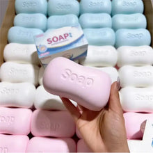 Un squishy savon souple rose avec le mot savon embossé sur une barre rectangulaire douce à retour lent