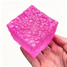 Cube squishy sensoriel à presser en forme de cube translucide rose vibrant avec surface texturée et bulles