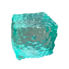 Cube squishy sensoriel en verre turquoise translucide avec surface texturée ondulée conçu pour presser