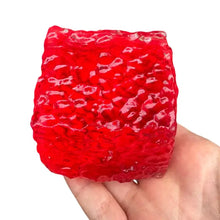 Cube squishy sensoriel rouge translucide en gelée avec surface texturée et bosses à presser pour détente sensorielle