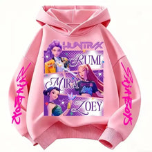 Sweat à capuche enfant rose avec graphique vibrant des chasseuses fantastiques rumi mira et zoey en lettres violettes