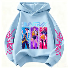 Sweat à capuche enfant bleu clair avec motifs de chasseuses fantastiques et texte rose stylisé sur les manches