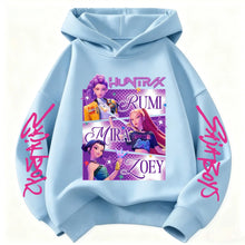 Sweat à capuche enfant bleu clair avec motifs animés de chasseuses fantastiques et texte rose cursif sur les manches