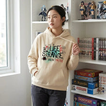Beige sweatshirt à capuche avec graphique life is strange en lettres noir rouge et vert pour style capuche life