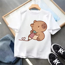 T-shirt blanc capybara en coton avec illustration dun capybara marron tenant un crayon rose et vert avec ligne en forme de cœur
