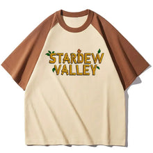 Cream-colored raglan t-shirt with brown sleeves featuring a pixelated stardrew valley graphic and green leaves t-shirt stardew valley