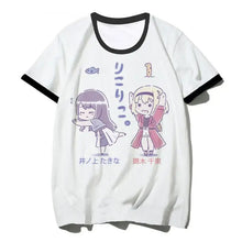 T-shirt manga duo blanc avec col noir et illustration cartoon de deux filles en tenues violette et rose duo d’action