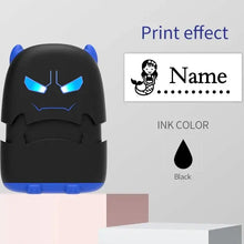Tampon prénom personnalisé encre noire et bleue en forme de monstre cartoon aux yeux bleus lumineux pour vêtements
