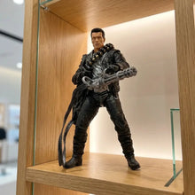 Figurine terminator t-800 en cuir noir articulée d arnold schwarzenegger tenant une mitrailleuse argentée avec câble enroulé