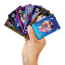 Une main tenant un éventail de cartes uno k-pop demon hunters colorées et brillantes avec illustrations de personnages vibrants