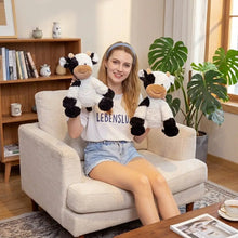 Peluche vache douce noire et blanche avec museau marron et sourire pour compagnon câlin convivial